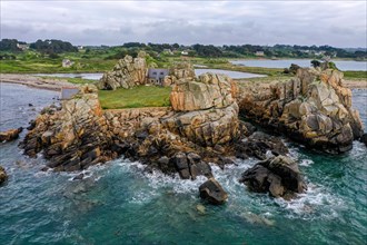Drone shot from the Atlantic Ocean onto the granite coast of Plougrescant with a view of the house between the rocks (Le gouffre de Plougrescant)