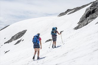 Two hikers on old snowfield