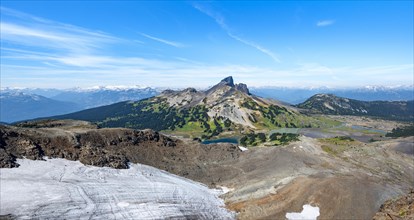Snowfield and blue lakes in front of the volcanic mountain Black Tusk