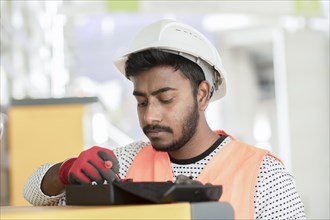 Young technician with beard working outside with helmet