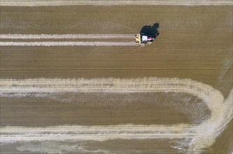Tractor sowing rice seeds in a flooded rice field in May
