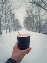 Person hand holding a cup of fresh