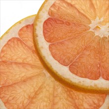 CUT OF GRAPEFRUIT citrus grandis AGAINST WHITE BACKGROUND