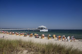 Beach chairs at Timmendorfer Strand with Seeschloesschenbruecke and Japanese teahouse