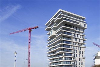 Lange Nelle lighthouse and new flat under construction for Oosteroever real estate project in Ostend harbour on the Belgian North Sea coast