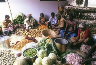 People cutting the vegetables in the age-old manner for a wedding feast in Chettinad
