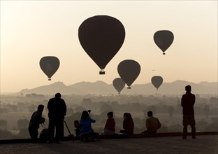 Tourists photographing hot air balloons