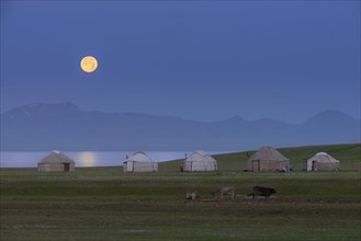 Moonrise over Song Kol Lake and nomadic yurts