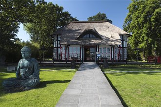 Thatched roof house Mikado Garden with Buddha rope