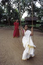 Swinging Two girls enjoying Onam holidays at Aranmula
