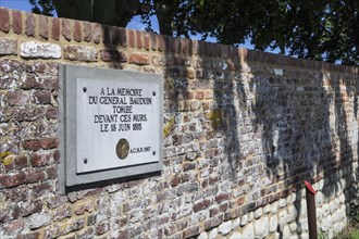 Memorial plaque to the fallen French General Bauduin in front of the garden wall of the Chateau d'Hougoumont