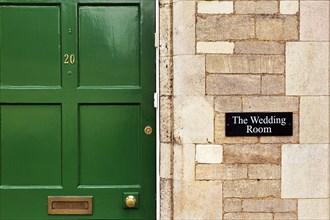 Facade with green door and sign Wedding Room