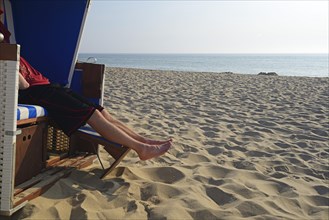 Tourist relaxing in a beach chair on the beach of Rantum