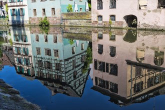 Half-timbered houses reflected in the ILL canal along the Quai de la Petite France
