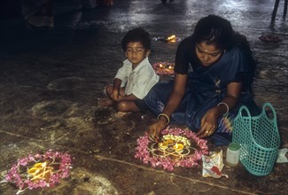 A woman lighting the oil lamp at a temple in Tamil Nadu