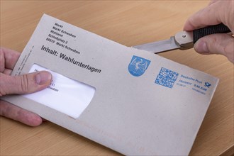 Man opens envelope with postal voting documents for the election of members of the German Bundestag on 26.09.2021