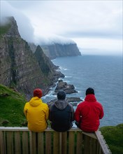 3 walkers sitting on wooden bench with view of Beinisforo cliffs
