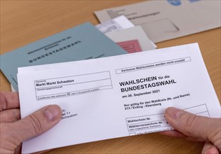 Hands holding a ballot paper for the election of members of the German Bundestag on 26.09.2021