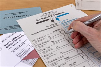 Hand with biros over ballot paper for the election of members of the German Bundestag on 26.09.2021