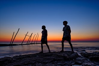 Silhouette of 2 boys by the sea