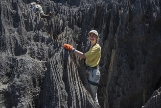 Woman climbing through rock needles of karst landscape
