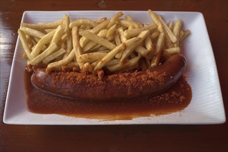 Currywurst served with fries in a beer garden
