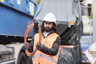 Technician with beard and helmet working in a recycling yard