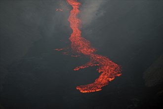 Glowing lava flows down mountainside