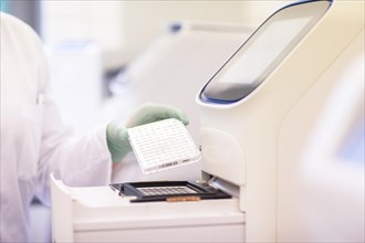 Multitube tray in one hand at a laboratory apparatus in a laboratory with laboratory glove