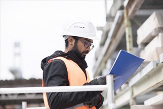 Technician with beard and helmet works in a workshop