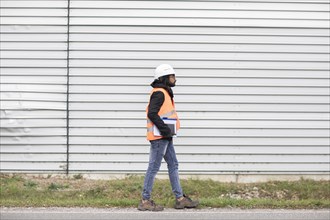 Technician with beard and helmet walking