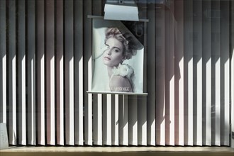 Advertising poster in the shop window of a hairdressing salon