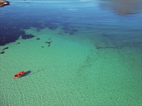 Red boat in crystal clear water