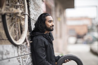 Young man with long hair at an old warehouse for tyres