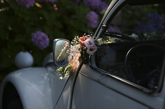 Wedding decoration on the wing mirror of a car