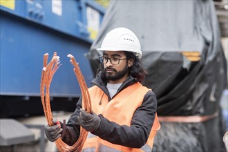 Technician with beard and helmet working in a recycling yard