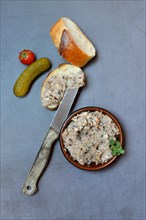 A bowl of meat terrine and slice of bread