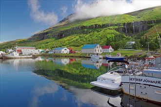 Boats and small houses reflected in the fjord
