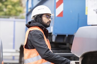 Technician with beard and helmet working on a truck