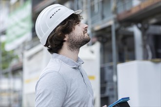 Technician with beard middle aged and working outside with polo shirt and helmet