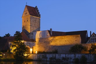Illuminated Rothenburg Gate with city wall at the city pond
