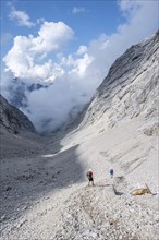 Two hikers descending through the Ofental valley
