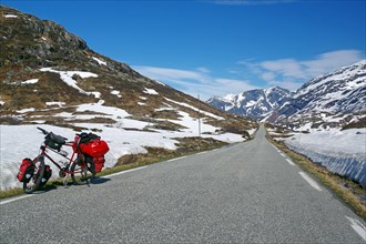Snow walls and touring bike along a road