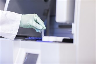 Nanotube in a hand at a laboratory device in a laboratory with laboratory glove