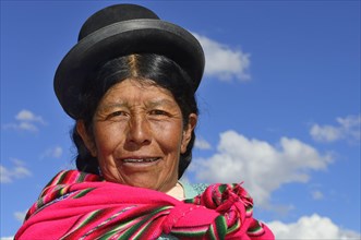 Older indigenous woman with hat smiling at the camera