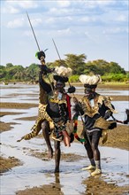 Men from the Toposa tribe posing in their traditional warrior costume