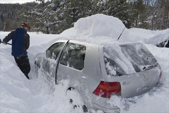 Man shovels car out of snow