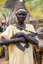 Woman from the Laarim tribe holding a rifle