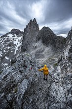 Hiker looking at mountains under dramatic clouds