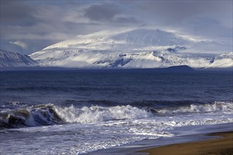Beach with surf and the volcano and glacier Snaefellsjoekull